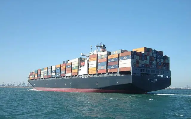 A fully-laden cargo ship sailing into port