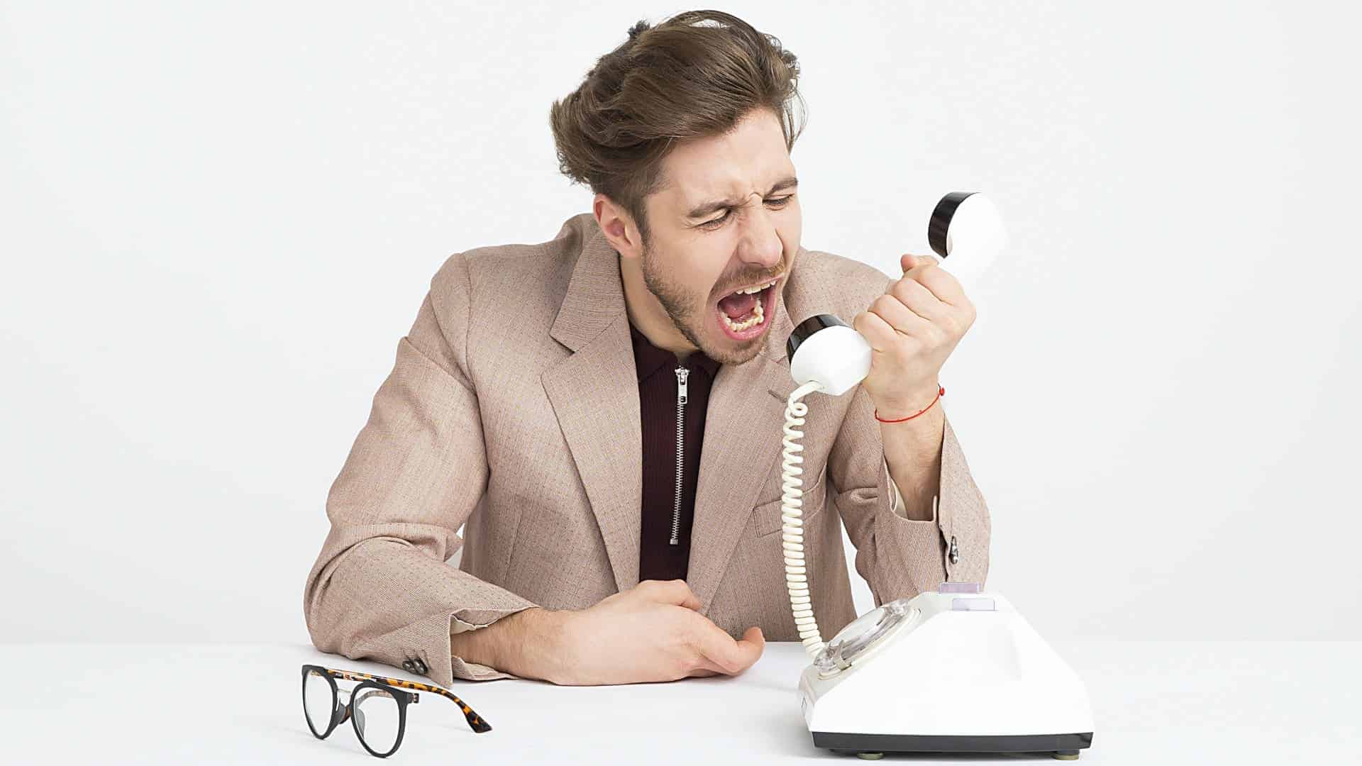 Man yelling into mouthpiece of a rotary phone