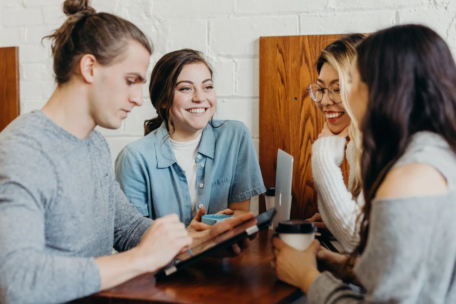 4 coworkers laughing at a cafe