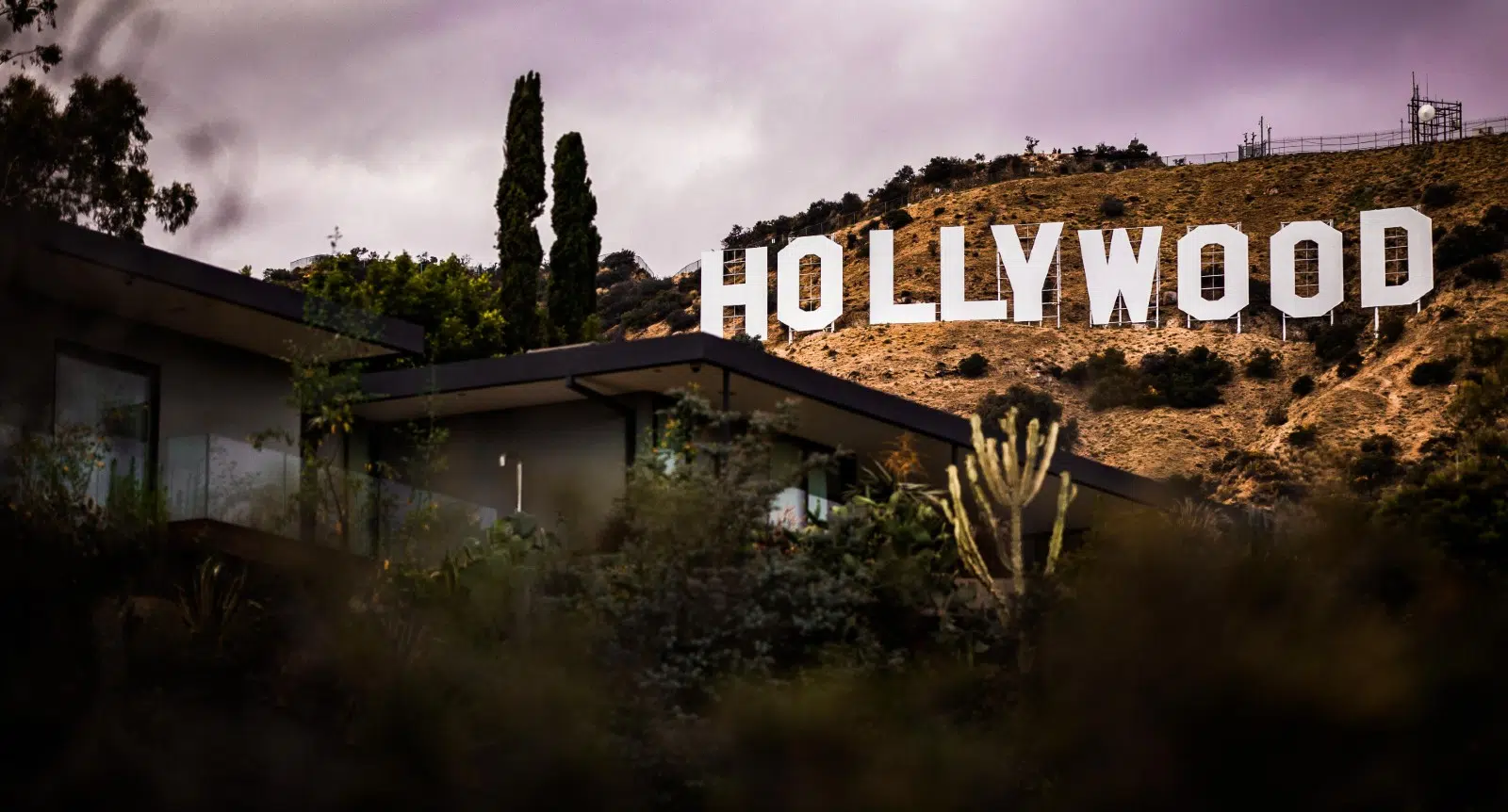 Photo of the Holly Wood sign behind a house on the hills