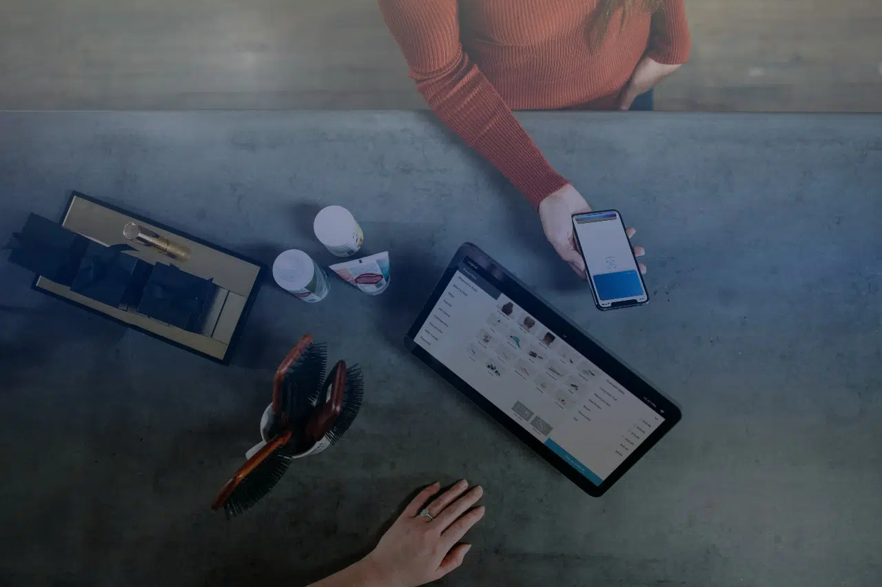 Overhead shot of woman paying for cosmetic products with smartphone