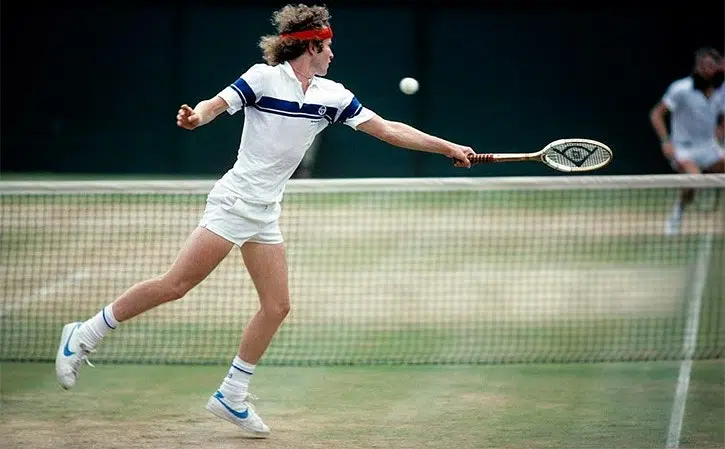 John Mcenroe hitting a backhand volley at Wimbledon